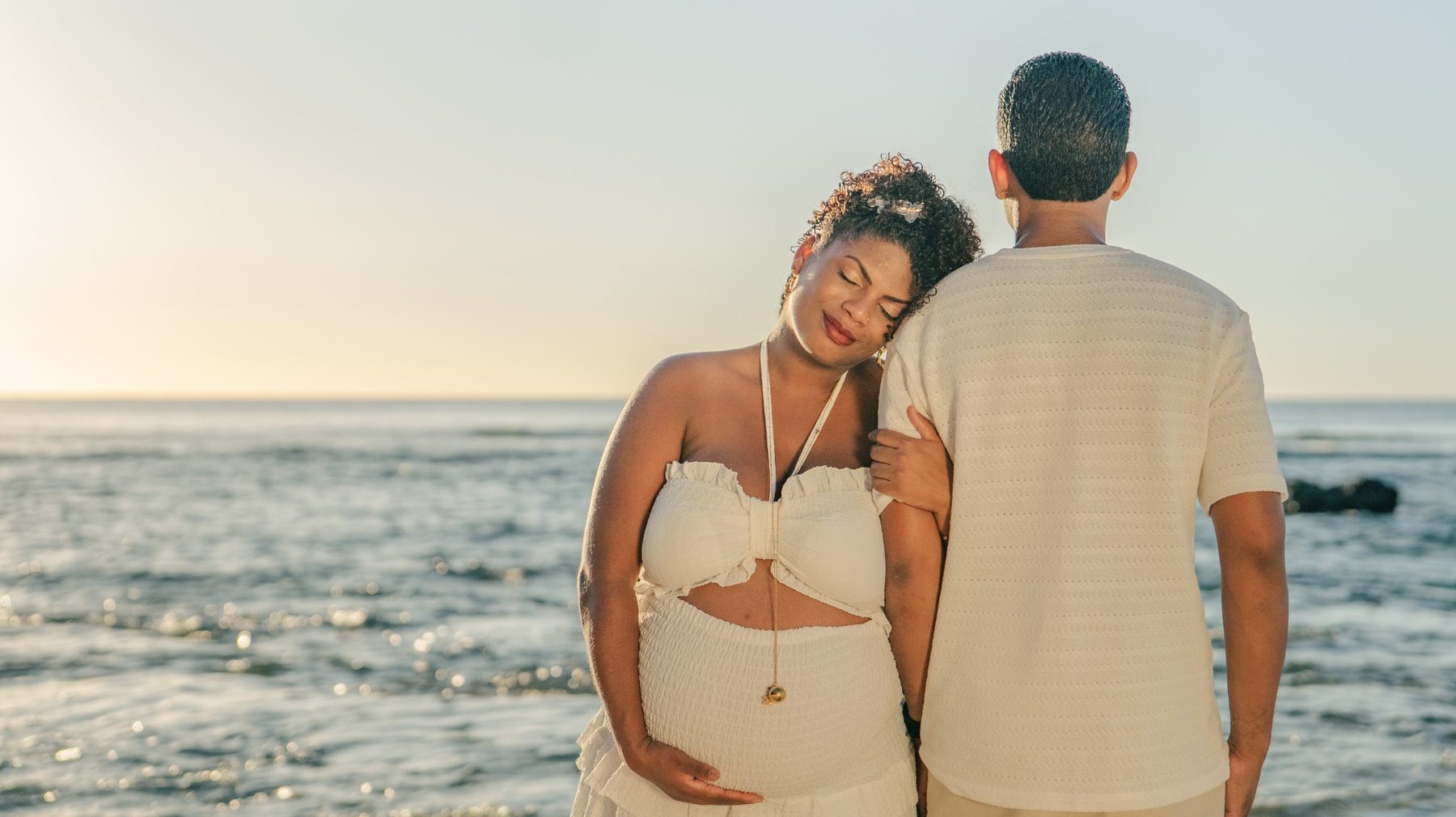 Couple lors d'une séance grossesse au bord de la mer